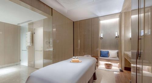 a bedroom with a large bed and a shower at Conrad Hangzhou in Hangzhou