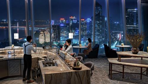a restaurant with a view of a city at night at Conrad Hangzhou in Hangzhou