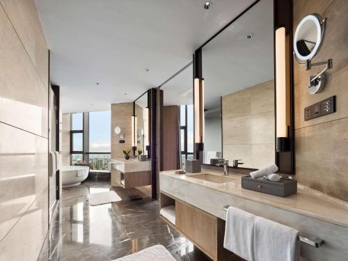a bathroom with two sinks and a large mirror at Hilton Jiaxing in Jiaxing