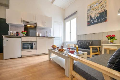 Il dispose d'une cuisine et d'un salon avec un canapé et une table. dans l'établissement Au cœur de St Martin : Le Grouin, à Saint-Martin-de-Ré