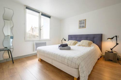 une chambre avec un grand lit dans une pièce dans l'établissement Au cœur de St Martin : Le Grouin, à Saint-Martin-de-Ré