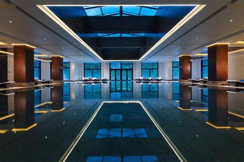 Habitación con piscina en medio de un edificio en Hilton Linzhi Resort en Nyingchi