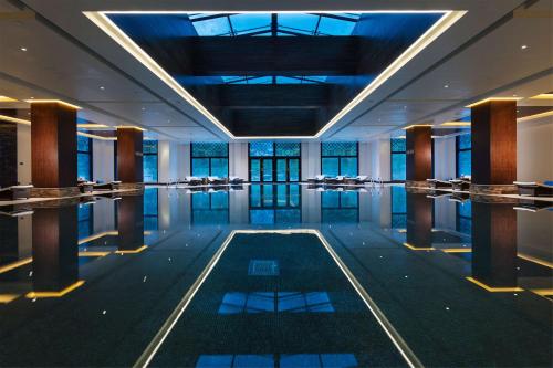 Hilton Linzhi Resort في نينغتشي: غرفة مع مسبح في وسط مبنى