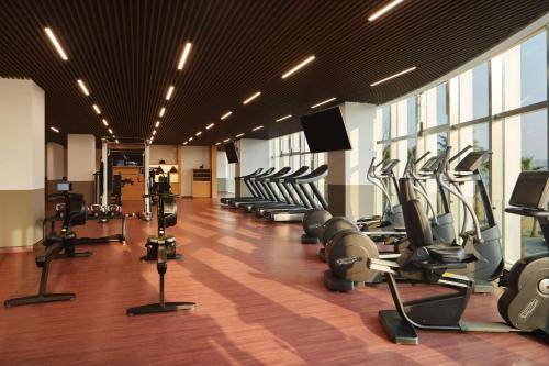 a gym with a row of treadmills and machines at Canopy By Hilton Hangzhou Jinsha Lake in Hangzhou