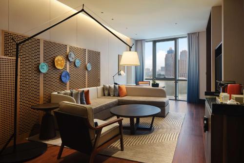 a living room with a couch and a table at Canopy By Hilton Hangzhou Jinsha Lake in Hangzhou