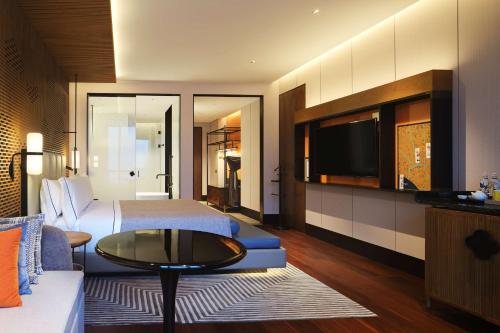 a hotel room with a bed and a tv at Canopy By Hilton Hangzhou Jinsha Lake in Hangzhou