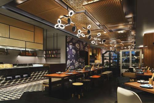a restaurant with tables and chairs and a bar at Canopy By Hilton Hangzhou Jinsha Lake in Hangzhou