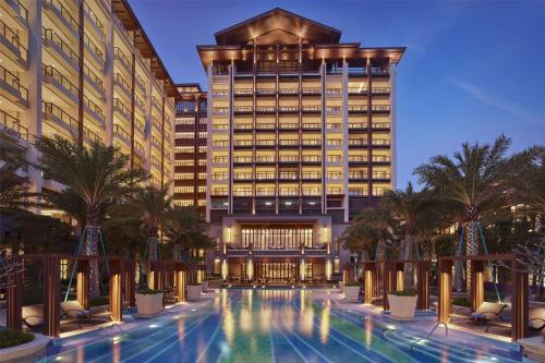 a hotel with a swimming pool in front of a building at Hilton Huizhou Longmen Resort in Huizhou