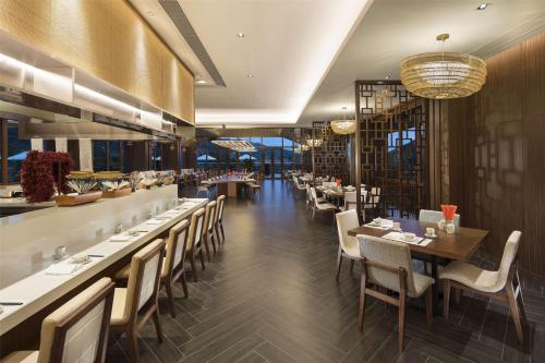 een restaurant met tafels en stoelen en een bar bij Hilton Huizhou Longmen Resort in Huizhou