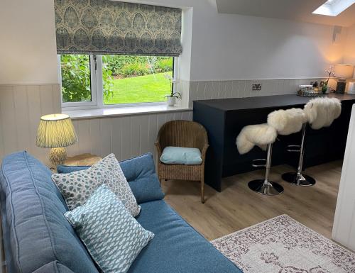 a living room with a blue couch and a window at Hillview Cottage in Edinburgh