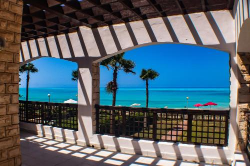 a view of the beach from the balcony of a resort at Sea Front Villa Direct Access to Crystal Blue Sea Al Alamein, Egypt in El Alamein
