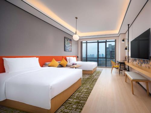Hilton Garden Inn Nanchang في نانتشانغ: غرفة فندقية بسريرين وتلفزيون بشاشة مسطحة