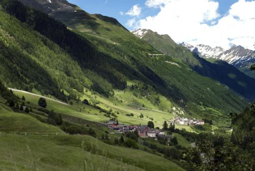 a valley with a village in the middle of a mountain at "CHALET dei FIORI" room & apartment in Bedretto