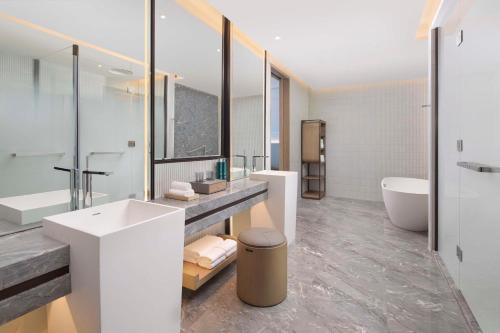 a bathroom with a sink and a tub and a toilet at Doubletree By Hilton Kunming Airport in Kunming