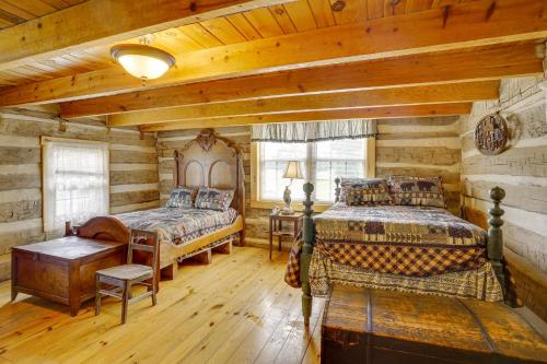a log cabin bedroom with two beds and a table at Historic Cabin Retreat about 2 Mi to Seneca Rocks! in Seneca Rocks