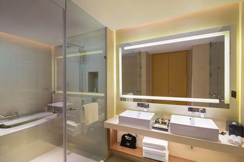 a bathroom with two sinks and a large mirror at Hilton Garden Inn Qidong in Qidong