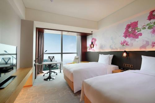 a hotel room with two beds and a desk at Hilton Garden Inn Zhuhai Hengqin in Zhuhai