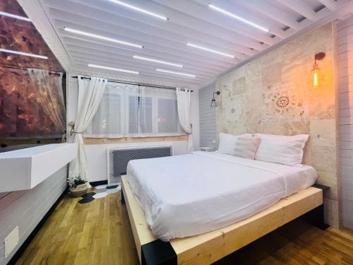ein Schlafzimmer mit einem großen Bett in einem Zimmer in der Unterkunft Arthitekt I Afi Cotroceni in Bukarest