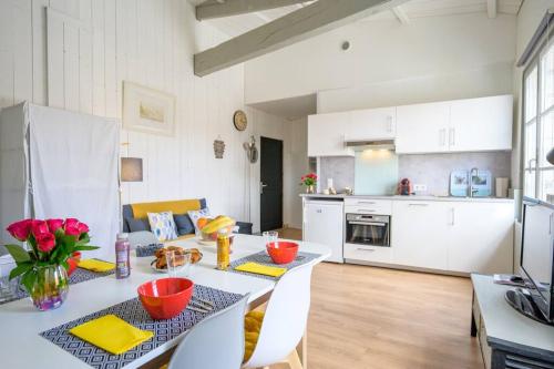 une cuisine et un salon avec une table et des chaises dans l'établissement Au cœur de St Martin : La Cible, à Saint-Martin-de-Ré