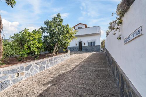 a road leading up to a white building at Raíces Vivas Vivienda Vacacional in Vega de San Mateo