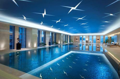 a swimming pool in a hotel with a blue ceiling at Hilton Nanjing in Nanjing