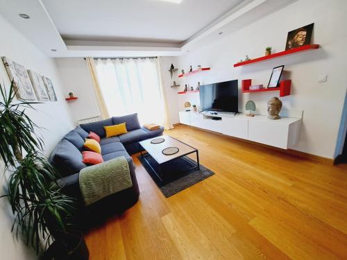 un salon avec un canapé bleu et une télévision dans l'établissement Appartement Bora Bora, à Narbonne