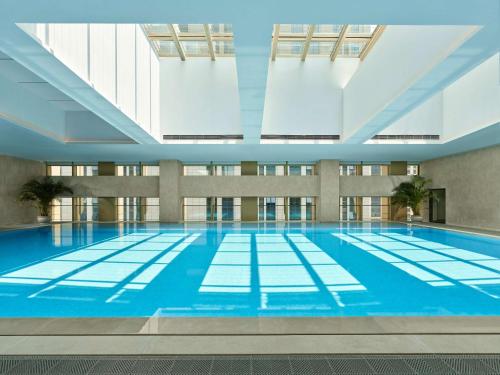 una grande piscina con acqua blu in un edificio di DoubleTree by Hilton Qidong a Qidong