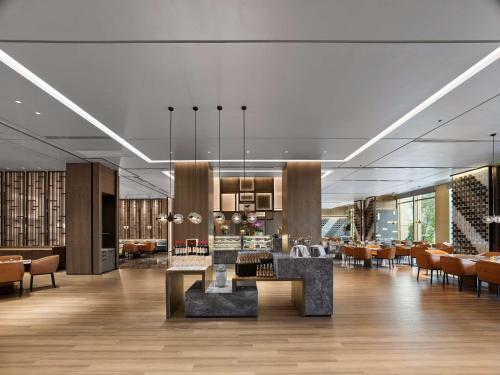 a lobby of a hotel with tables and chairs at DoubleTree by Hilton Qidong in Qidong