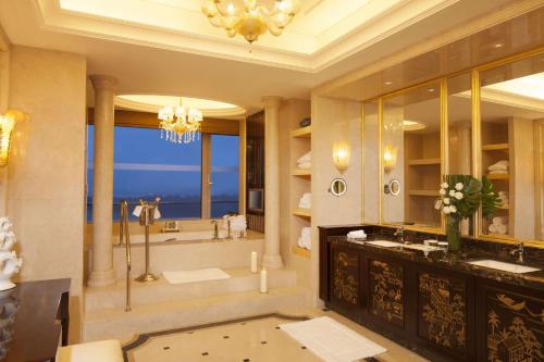 bagno con 2 lavandini e vasca con doccia di Hilton Nanjing Riverside a Nanjing