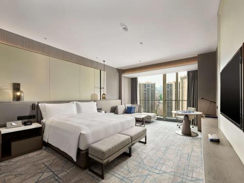 a hotel room with a large bed and a television at DoubleTree by Hilton Qidong in Qidong