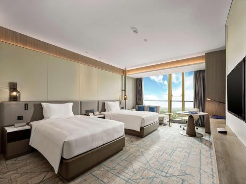 Postel nebo postele na pokoji v ubytování DoubleTree by Hilton Qidong
