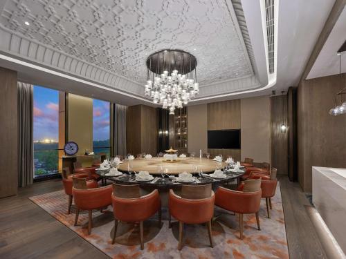 a dining room with a table and chairs and a chandelier at DoubleTree by Hilton Qidong in Qidong