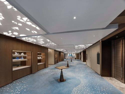 a long hallway with a table in the middle of a room at DoubleTree by Hilton Qidong in Qidong