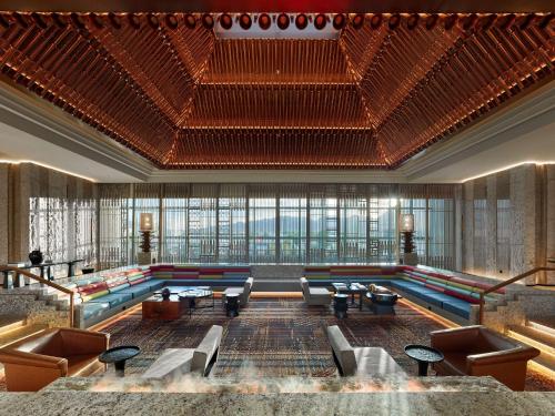a large lobby with couches and a pool at Hilton Shigatse in Shigatse