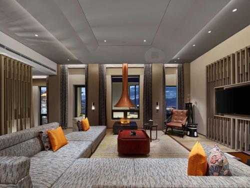 a living room with a couch and a tv at Hilton Shigatse in Shigatse