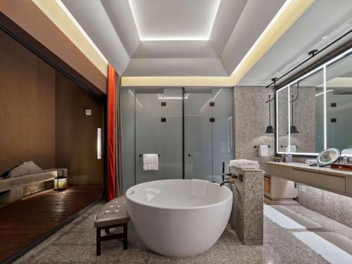 a bathroom with a large tub and a sink at Hilton Shigatse in Shigatse