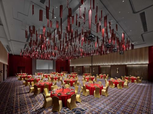 a banquet hall with red tables and chairs and chandeliers at Hilton Shigatse in Shigatse
