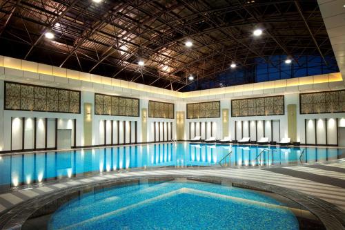 - une grande piscine d'eau bleue dans un bâtiment dans l'établissement DoubleTree by Hilton Shenyang, à Shenyang