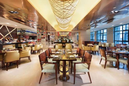 een restaurant met tafels en stoelen en een bar bij DoubleTree by Hilton Shenyang in Shenyang