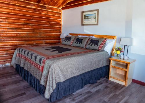 een slaapkamer met een bed en een houten muur bij Creekside Cabins in Saint Ignatius