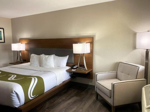 Habitación de hotel con cama y silla en Quality Inn & Suites Near White Sands National Park, en Alamogordo