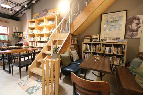 a library with a staircase and tables and bookshelves at 微光書旅-輕旅 in Tongluo