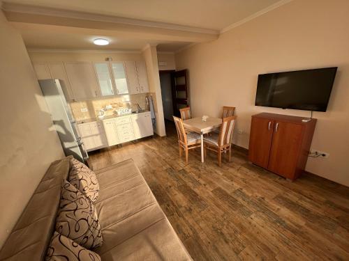 Una sala de estar con una mesa y un televisor. en Apartment Sea View Dobra Voda, en Dobra Voda