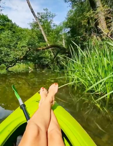 a persons feet on a kayak on a river at Bobrowa Ostoja in Łukta