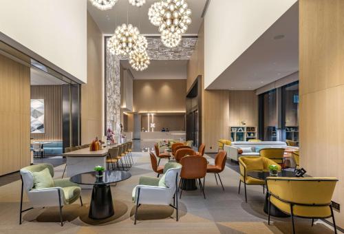 a lobby of a hotel with tables and chairs at Hilton Garden Inn Shenzhen World Exhibition & Convention Center in Shenzhen