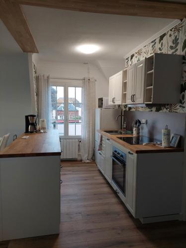 une cuisine avec des appareils blancs et un parquet dans l'établissement Au gré des marées 2 appartement face à la mer 2ème étage, à Ault