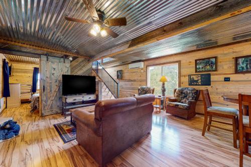 a living room with a couch and a flat screen tv at Great Smoky Hideout in Gatlinburg