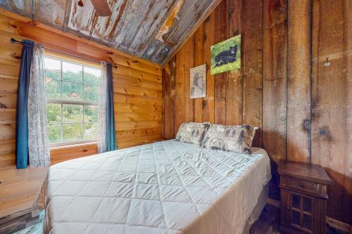 um quarto com uma cama num chalé de madeira em Great Smoky Hideout em Gatlinburg