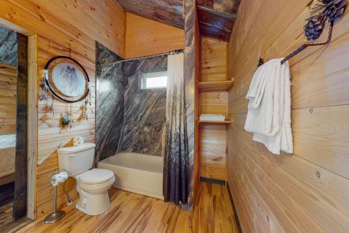 a bathroom with a toilet and a bath tub at Great Smoky Hideout in Gatlinburg