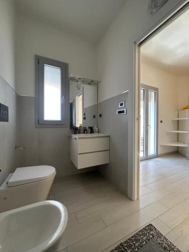 La salle de bains est pourvue de toilettes blanches et d'un lavabo. dans l'établissement Domu Dina Affittacamere 1, à Tertenìa